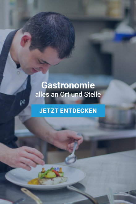 Vordergrund mit Schriftzug: „Gastronomie alles an Ort und Stelle“ dazu der Button: „Jetzt entdecken“. Im Hintergrund ein Koch in einer Küche, welcher ein Gericht vorbereitet. Vor Ihm ein mit Essen befüllter Teller.