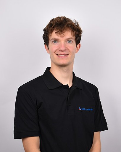 Bild von einem Mann mit braunen Haaren. Er trägt ein T-Shirt mit der Aufschrift „Orgami Sistec“ und dem dazugehörigen Logo. Er steht vor einem weißen Hintergrund.