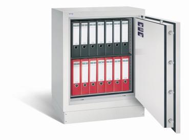 Geöffneter lichtgrauer Dokumentenschrank mit sichtbarer Türverriegelung und Zertifikaten an der Türinnenseite. Innenraum mit einem Fachboden und zwei Reihen Aktenordnern in Schwarz und Rot. Der Tresor steht vor weißem Hintergrund.