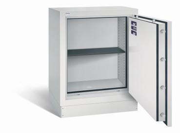 Geöffneter lichtgrauer Dokumentenschrank mit sichtbarer Türverriegelung und Zertifikaten an der Türinnenseite. Innenraum mit einem höhenverstellbaren Fachboden. Der Tresor steht vor weißem Hintergrund.