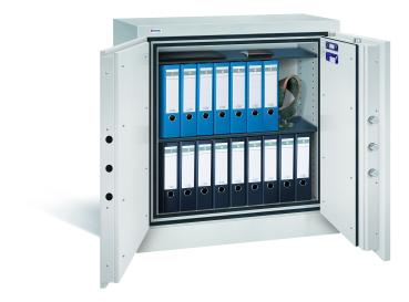 Lichtgrauer Dokumentenschrank mit zwei Türen und sichtbarer Türverriegelung. Innenraum mit zwei Fachböden, blauen und schwarzen Aktenordnern. Auf dem obersten Fachboden liegen ein Laptop und ein Portmonee. Weißer Hintergrund.