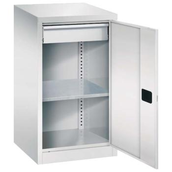 Lichtgrauer Beistellschrank mit geöffneter Tür und Zylinderschloss. Im Inneren hat der Schrank insgesamt 1 höhenverstellbaren Fachboden und 1 Schublade. Im unteren Bereich ist ein Stahlblechsockel. Der Schrank steht vor einem weißen Hintergrund.
