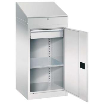 Lichtgrauer Beistellschrank mit geöffneter Tür und Zylinderschloss vor einem weißen Hintergrund. Im unteren Bereich 1 höhenverstellbaren Fachboden, eine Schublade und ein Stahlblechsockel. Im oberen Bereich ist ein Schreibpultaufsatz.