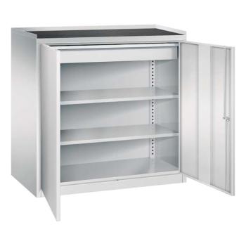 Lichtgrauer Werkstattschrank mit geöffneten Türen und Zylinderschloss vor einem weißen Hintergrund. Der Schrank hat 2 höhenverstellbare Fachböden und eine Schublade. Auf dem Schrank ist eine Rillengummi Auflage. Am Boden befindet sich ein Stahlblechsockel