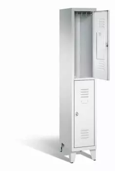 Ein lichtgrauer Garderobenschrank mit einem Abteil, zwei Fächern sowie integrierten Kleiderstangen mit Kleiderhaken, dessen obere Tür geöffnet ist. Er steht auf Stahlblechfüßen vor weißem Hintergrund.