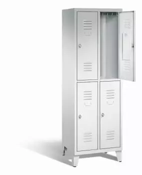 Ein lichtgrauer Garderobenschrank mit zwei Abteilen, vier Fächern sowie integrierten Kleiderstangen mit Kleiderhaken, dessen obere rechte Tür geöffnet ist. Er steht auf Stahlblechfüßen vor weißem Hintergrund.