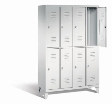 Ein lichtgrauer Garderobenschrank mit vier Abteilen, acht Fächern sowie integrierten Kleiderstangen mit Kleiderhaken, dessen obere rechte Tür geöffnet ist. Er steht auf Stahlblechfüßen vor weißem Hintergrund.