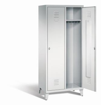 Ein lichtgrauer Garderobenschrank mit zwei Abteilen, zwei Fächern sowie integrierten Kleiderstangen mit Kleiderhaken, dessen rechte Tür geöffnet ist. Er steht auf Stahlblechfüßen vor weißem Hintergrund.