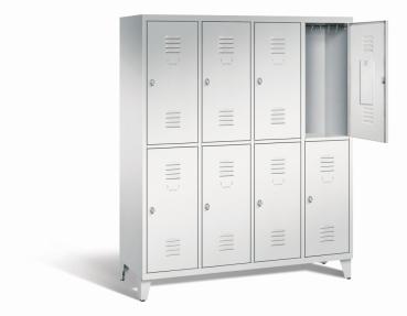Ein lichtgrauer Garderobenschrank mit vier Abteilen, acht Fächern sowie integrierten Kleiderstangen mit Kleiderhaken, dessen obere rechte Tür geöffnet ist. Er steht auf Stahlblechfüßen vor weißem Hintergrund.