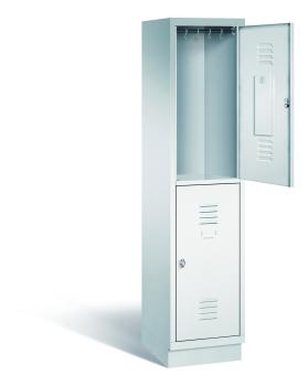 Ein lichtgrauer Garderobenschrank mit einem Abteil, zwei Fächern sowie integrierten Kleiderstangen mit Kleiderhaken, dessen obere Tür geöffnet ist. Er steht auf einem Stahlblechsockel vor weißem Hintergrund.