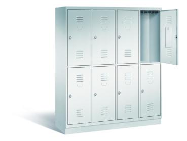 Ein lichtgrauer Garderobenschrank mit vier Abteilen, acht Fächern sowie integrierten Kleiderstangen mit Kleiderhaken, dessen obere rechte Tür geöffnet ist. Er steht auf einem Stahlblechsockel vor weißem Hintergrund.