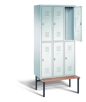 Ein lichtgrauer Garderobenschrank mit drei Abteilen, sechs Fächern sowie integrierten Kleiderstangen mit Kleiderhaken, dessen obere rechte Tür geöffnet ist. Er steht auf einer unter- und vorgebauten Sitzbank vor weißem Hintergrund.