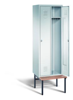 Ein lichtgrauer Garderobenschrank mit zwei Abteilen, zwei Fächern sowie integrierten Kleiderstangen mit Kleiderhaken, dessen rechte Tür geöffnet ist. Er steht auf einer unter- und vorgebauten Sitzbank vor weißem Hintergrund.