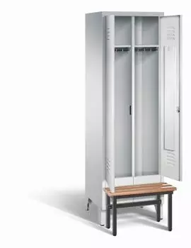 Ein lichtgrauer Garderobenschrank mit zwei Abteilen, zwei Fächern sowie integrierten Kleiderstangen mit Kleiderhaken, dessen Türen geöffnet sind. Er steht auf Stahlblechfüßen und hat eine vorgebaute Sitzbank vor weißem Hintergrund.
