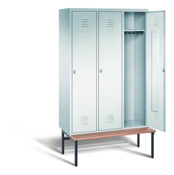 Ein lichtgrauer Garderobenschrank mit drei Abteilen, drei Fächern sowie integrierten Kleiderstangen mit Kleiderhaken, dessen rechte Tür geöffnet ist. Er steht auf einer unter- und vorgebauten Sitzbank vor weißem Hintergrund.
