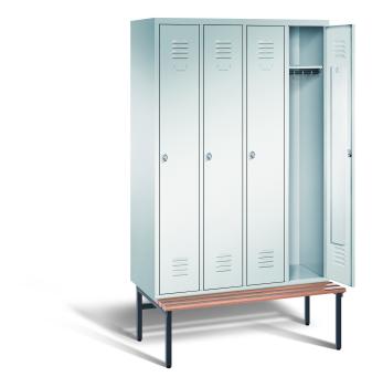 Ein lichtgrauer Garderobenschrank mit vier Abteilen, vier Fächern sowie integrierten Kleiderstangen mit Kleiderhaken, dessen rechte Tür geöffnet ist. Er steht auf einer unter- und vorgebauten Sitzbank vor weißem Hintergrund.