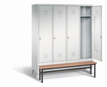 Ein lichtgrauer Garderobenschrank mit vier Abteilen, vier Fächern sowie integrierten Kleiderstangen mit Kleiderhaken, dessen rechte Tür geöffnet ist. Er steht auf Stahlblechfüßen und hat eine vorgebaute Sitzbank vor weißem Hintergrund.