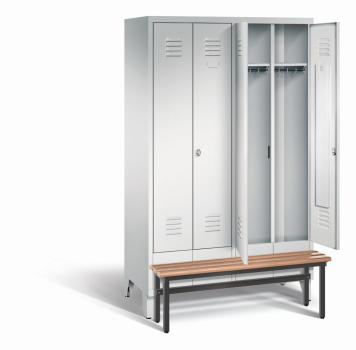 Ein lichtgrauer Garderobenschrank mit vier Abteilen, vier Fächern sowie integrierten Kleiderstangen mit Kleiderhaken, dessen beide rechten Türen geöffnet sind. Er steht auf Stahlblechfüßen und hat eine vorgebaute Sitzbank vor weißem Hintergrund.