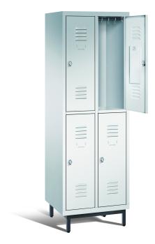 Ein lichtgrauer Garderobenschrank mit zwei Abteilen, vier Fächern sowie integrierten Kleiderstangen mit Kleiderhaken, dessen obere rechte Tür geöffnet ist. Er steht auf Stahlrohrfüßen vor weißem Hintergrund.