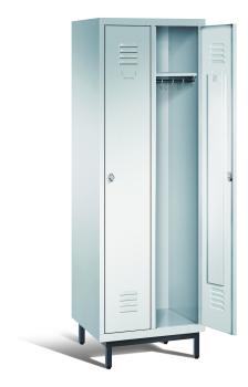 Ein lichtgrauer Garderobenschrank mit zwei Abteilen, zwei Fächern sowie integrierten Kleiderstangen mit Kleiderhaken, dessen rechte Tür geöffnet ist. Er steht auf Stahlrohrfüßen vor weißem Hintergrund.