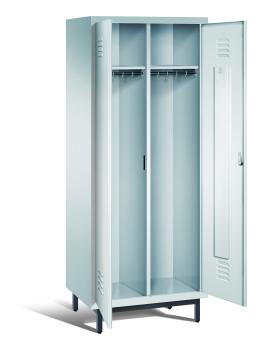 Ein lichtgrauer Garderobenschrank mit zwei Abteilen, zwei Fächern sowie integrierten Kleiderstangen mit Kleiderhaken, dessen Türen geöffnet sind. Er steht auf Stahlrohrfüßen vor weißem Hintergrund.