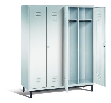 Ein lichtgrauer Garderobenschrank mit vier Abteilen, vier Fächern sowie integrierten Kleiderstangen mit Kleiderhaken, dessen beiden rechten Türen geöffnet sind. Er steht auf Stahlrohrfüßen vor weißem Hintergrund.