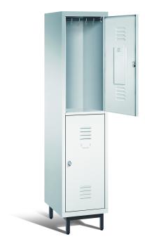 Ein lichtgrauer Garderobenschrank mit einem Abteil, zwei Fächern sowie integrierten Kleiderstangen mit Kleiderhaken, dessen obere Tür geöffnet ist. Er steht auf Stahlrohrfüßen vor weißem Hintergrund.