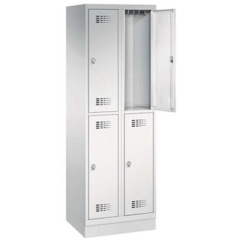 Ein lichtgrauer Garderobenschrank mit zwei Abteilen, vier Fächern sowie integrierten Kleiderstangen mit Kleiderhaken, dessen obere rechte Tür geöffnet ist. Er steht auf einem Stahlblechsockel vor weißem Hintergrund.