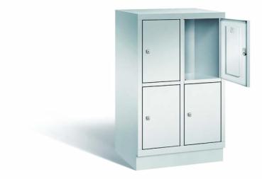 Lichtgrauer Fächerschrank mit zwei Abteilen, vier Türen und vier Fächern, ideal zur Aufbewahrung von Gegenständen. Steht vor einem weißen Hintergrund.