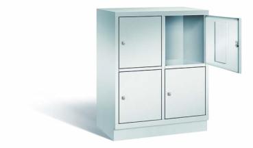 Lichtgrauer Fächerschrank mit zwei Abteilen, vier Türen und vier Fächern, ideal zur Aufbewahrung von Gegenständen. Steht vor einem weißen Hintergrund.