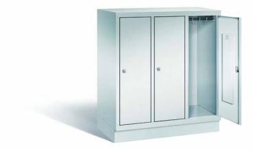 Lichtgrauer Fächerschrank mit drei Abteilen, drei Türen und drei Fächern. Integrierte Kleiderstange mit Kleiderhaken im Spind für praktische Aufbewahrung. Ideal zur Lagerung von Kleidung und anderen Gegenständen. Steht vor einem weißen Hintergrund.