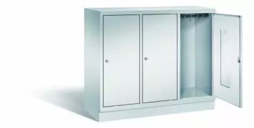 Lichtgrauer Fächerschrank mit drei Abteilen, drei Türen und drei Fächern. Integrierte Kleiderstange mit Kleiderhaken im Spind für praktische Aufbewahrung. Ideal zur Lagerung von Kleidung und anderen Gegenständen. Steht vor einem weißen Hintergrund.