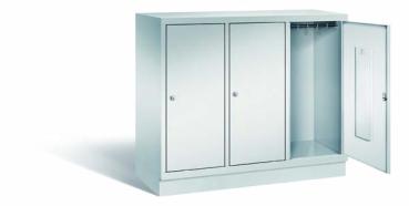 Lichtgrauer Fächerschrank mit drei Abteilen, drei Türen und drei Fächern. Integrierte Kleiderstange mit Kleiderhaken im Spind für praktische Aufbewahrung. Ideal zur Lagerung von Kleidung und anderen Gegenständen. Steht vor einem weißen Hintergrund.