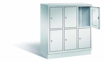 Lichtgrauer Fächerschrank mit drei Abteilen, sechs Türen und sechs Fächern, ideal zur Aufbewahrung von Gegenständen. Steht vor einem weißen Hintergrund.