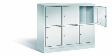 Lichtgrauer Fächerschrank mit drei Abteilen, sechs Türen und sechs Fächern, ideal zur Aufbewahrung von Gegenständen. Steht vor einem weißen Hintergrund.