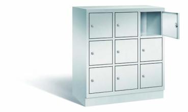 Lichtgrauer Fächerschrank mit drei Abteilen, neun Türen und neun Fächern, ideal zur Aufbewahrung von Gegenständen. Steht vor einem weißen Hintergrund.