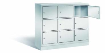 Lichtgrauer Fächerschrank mit drei Abteilen, neun Türen und neun Fächern, ideal zur Aufbewahrung von Gegenständen. Steht vor einem weißen Hintergrund.
