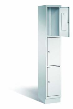 Lichtgrauer Fächerschrank mit einem Abteil, drei Türen und drei Fächern, ideal zur Aufbewahrung von Gegenständen. Steht vor einem weißen Hintergrund.