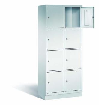 Ein lichtgrauer Fächerschrank mit zwei Abteilen, acht Türen und acht Fächern, ideal zur Aufbewahrung von Gegenständen. Die obere rechte Tür ist geöffnet, während der Schrank vor einem weißen Hintergrund steht.