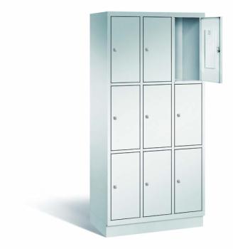 Ein lichtgrauer Fächerschrank mit drei Abteilen, neun Türen und neun Fächern, ideal zur Aufbewahrung von Gegenständen. Die obere rechte Tür ist geöffnet, während der Schrank vor einem weißen Hintergrund steht.