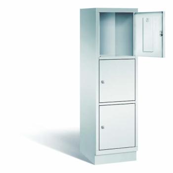 Ein lichtgrauer Fächerschrank mit einem Abteil, drei Türen und drei Fächern, ideal zur Aufbewahrung von Gegenständen. Die oberste der drei Türen steht offen und er steht vor einem weißen Hintergrund.