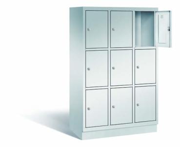 Ein lichtgrauer Fächerschrank mit drei Abteilen, neun Türen und neun Fächern, ideal zur Aufbewahrung von Gegenständen. Die obere rechte Tür ist geöffnet, während der Schrank vor einem weißen Hintergrund steht.