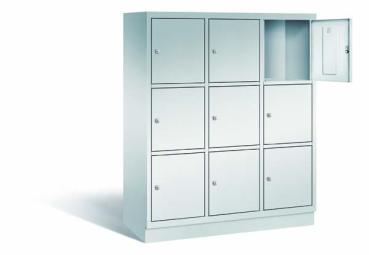 Ein lichtgrauer Fächerschrank mit drei Abteilen, neun Türen und neun Fächern, ideal zur Aufbewahrung von Gegenständen. Die obere rechte Tür ist geöffnet, während der Schrank vor einem weißen Hintergrund steht.