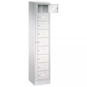 Lichtgrauer Wäschetauschrank vor weißem Hintergrund mit Drehriegel. Der Schrank besitzt 9 Fächer, wovon das erste geöffnet ist. Unterhalb befindet sich ein Stahlblechsockel.