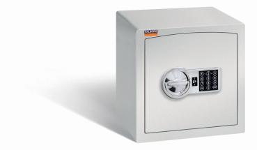 Ein lichtgrauer Möbeltresor mit einem elektronischen Schloss. Die Tür ist geschlossen. Der Tresor steht vor einem weißen Hintergrund.