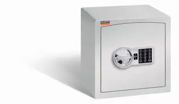 Ein lichtgrauer Möbeltresor mit einem elektronischen Schloss. Die Tür ist geschlossen. Der Tresor steht vor einem weißen Hintergrund.