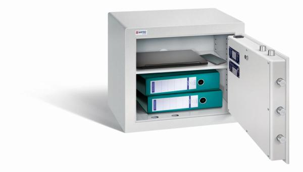 Geöffneter lichtgrauer Möbeltresor mit massivem Korpus und offener Tür. Im inneren befindet sich ein höhenverstellbarer Fachboden mit 2 Ordner, ein Laptop und ein Handy. Der Tresor steht vor einem weißen Hintergrund.