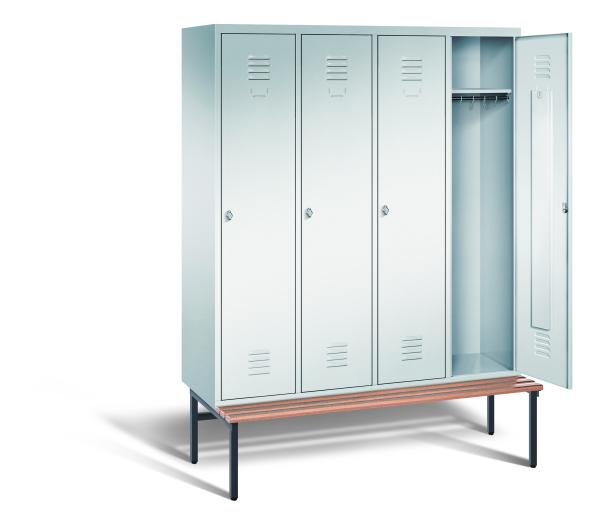 Ein lichtgrauer Garderobenschrank mit vier Abteilen, vier Fächern sowie integrierten Kleiderstangen mit Kleiderhaken, dessen rechte Tür geöffnet ist. Er steht auf einer unter- und vorgebauten Sitzbank vor weißem Hintergrund.