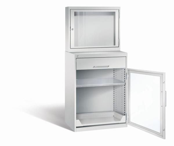 Lichtgrauer Computerschrank mit abschließbarem Sichtfenster im oberen Bereich und geöffneter Acrylglas-Stahltür im unteren Bereich mit Schublade und einem höhenverstellbarer Fachboden sowie Auszugsboden. Der Schrank steht vor weißem Hintergrund.