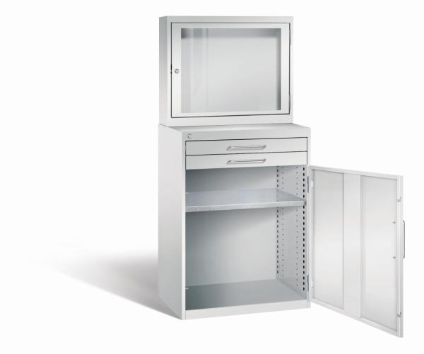 Lichtgrauer Computerschrank mit abschließbarem Sichtfenster im oberen Bereich und geöffneter Stahltür mit zwei Schubladen im unteren Bereich und einem höhenverstellbarer Fachboden. Der Schrank steht vor weißem Hintergrund.